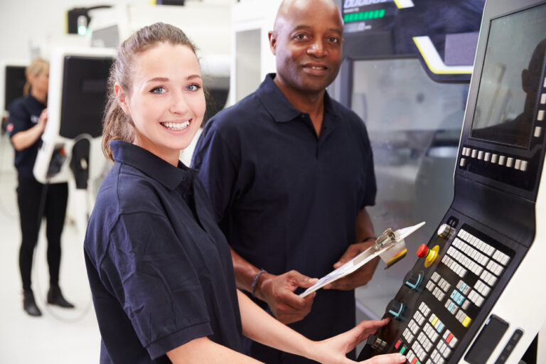 Woman and man operating the controls pf machinery